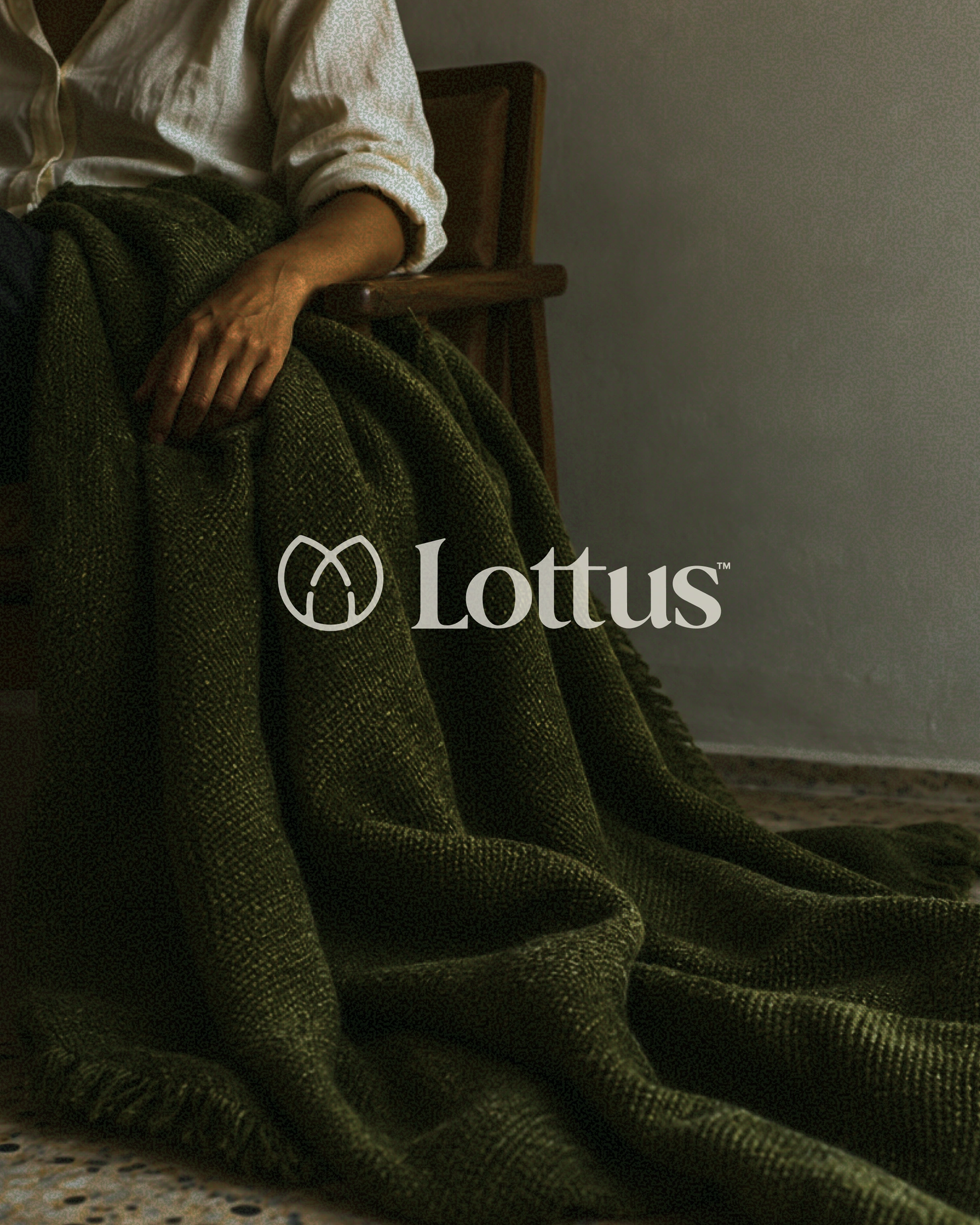 Lottus ivory signature over a seated person and draped olive fabric